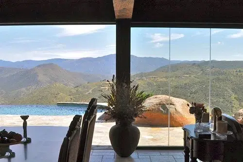 Frameless sliding glass doors with pool and view of mountains.