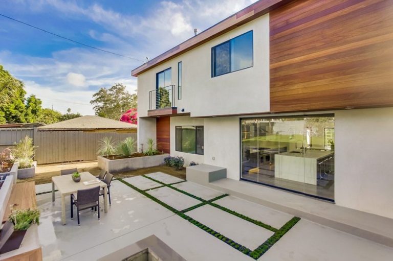 Patio with table and enclosed frameless sliding glass doors.