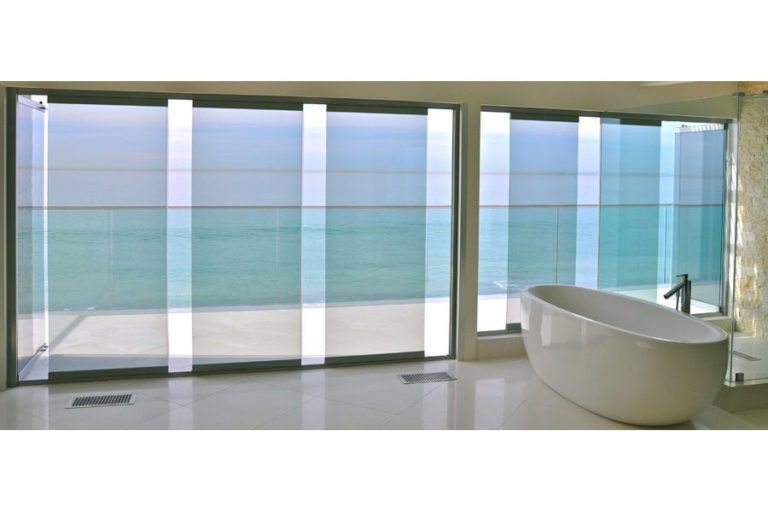 Bath tub with staggered frameless glass sliding doors and windows.