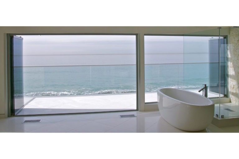 Bath tub with stacked frameless sliding glass doors and windows.