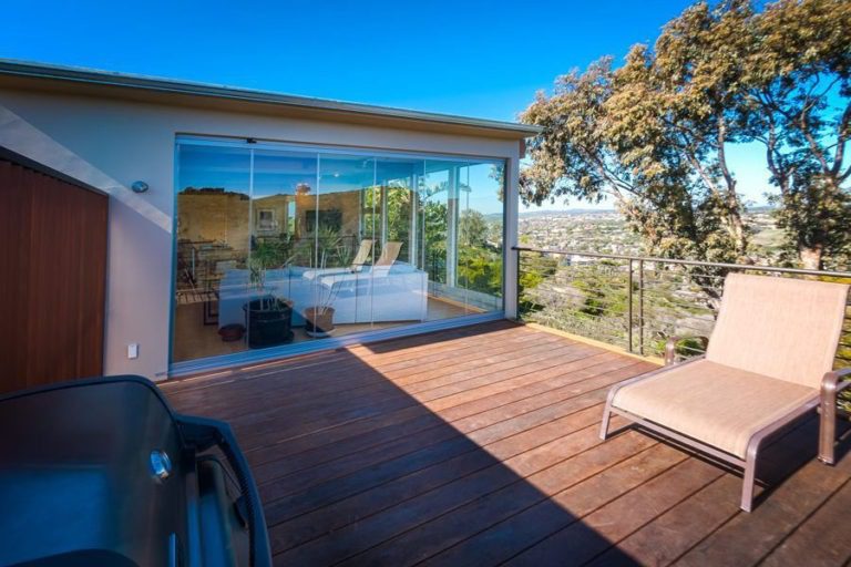 Patio looking into living room with enclosed frameless sliding glass doors.