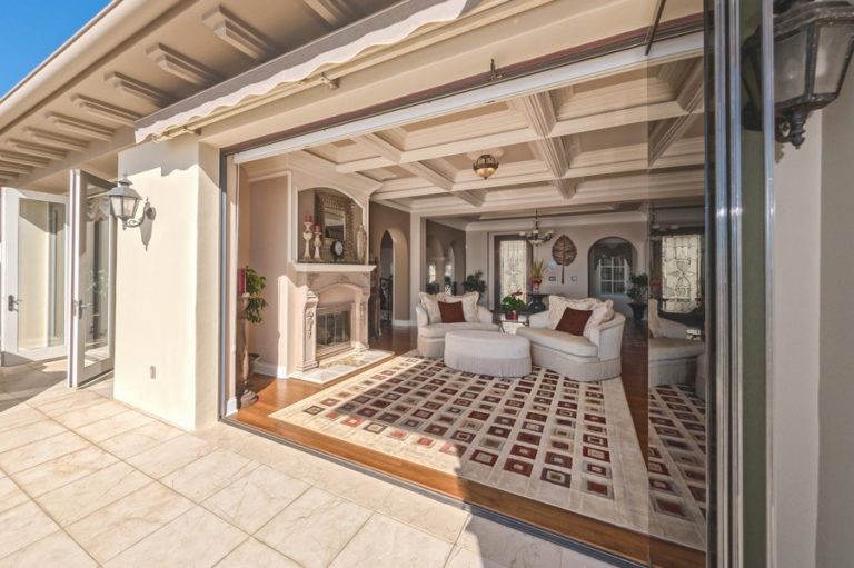 Living room with stacked frameless sliding glass doors.