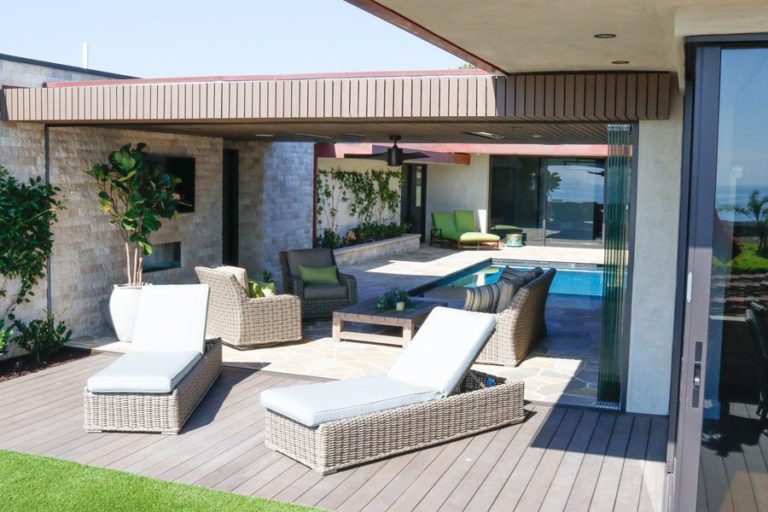 Stacked sliding glass doors creating an open area between yard and indoor patio with swimming pool.