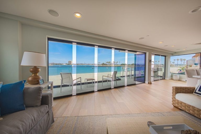 Looking from living and dining room out to patio with an staggered frameless sliding glass doors.