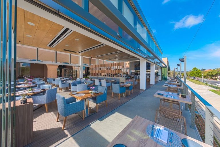 Restaurant dining area with stacked frameless sliding glass doors and patio.