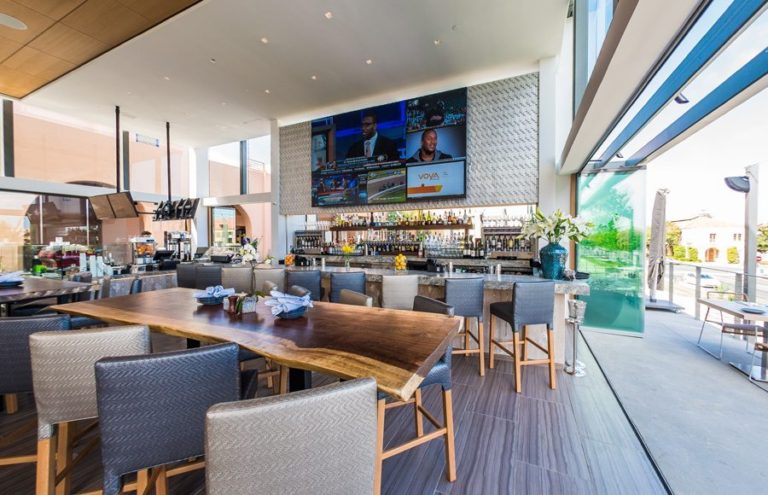 Restaurant bar with stacked frameless sliding glass doors.