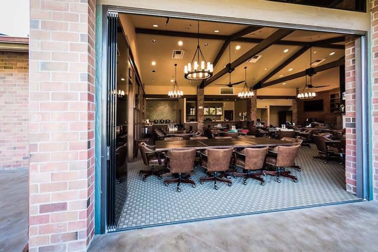 Stacked frameless glass doors showing the inside of a country club.