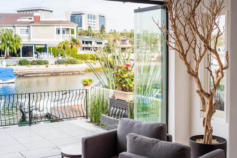 Corner of living room with stacked sliding glass doors overlooking the patio and river.