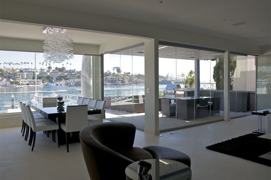 Inside living room of a home looking at the bay view through frameless glass windows.