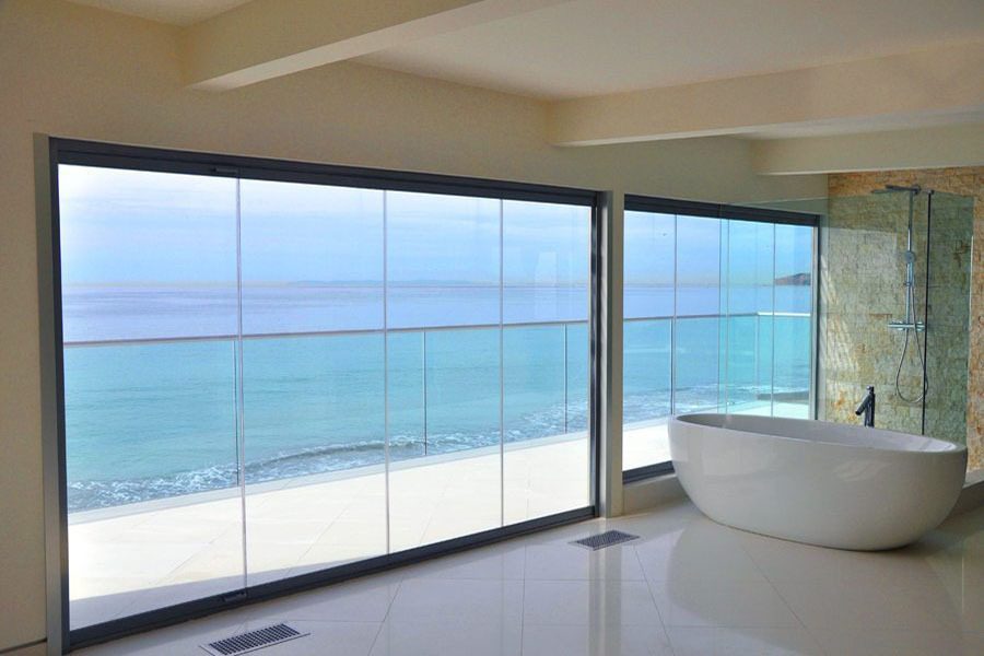 Bath tub with enclosed frameless sliding glass doors and windows.