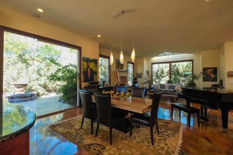 Dining room with piano and half open sliding glass doors connecting to the outdoor patio.