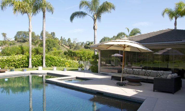 Pool and patio with enclosed frameless glass sliding doors.