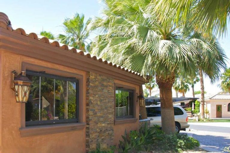 Residence from the outside featuring closed frameless sliding glass windows.