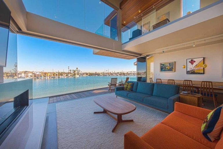 Living room with stacked frameless sliding glass doors with view of bay.