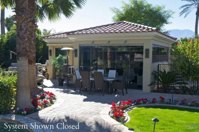 Overview of the residence from the outside featuring closed frameless sliding glass doors.