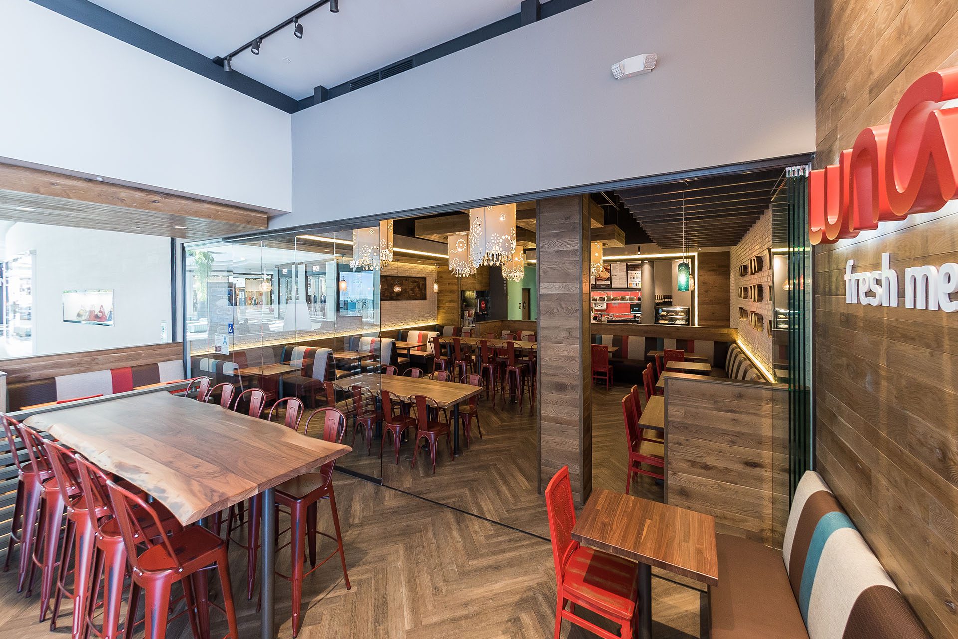 Restaurant with tables and frameless sliding glass doors.