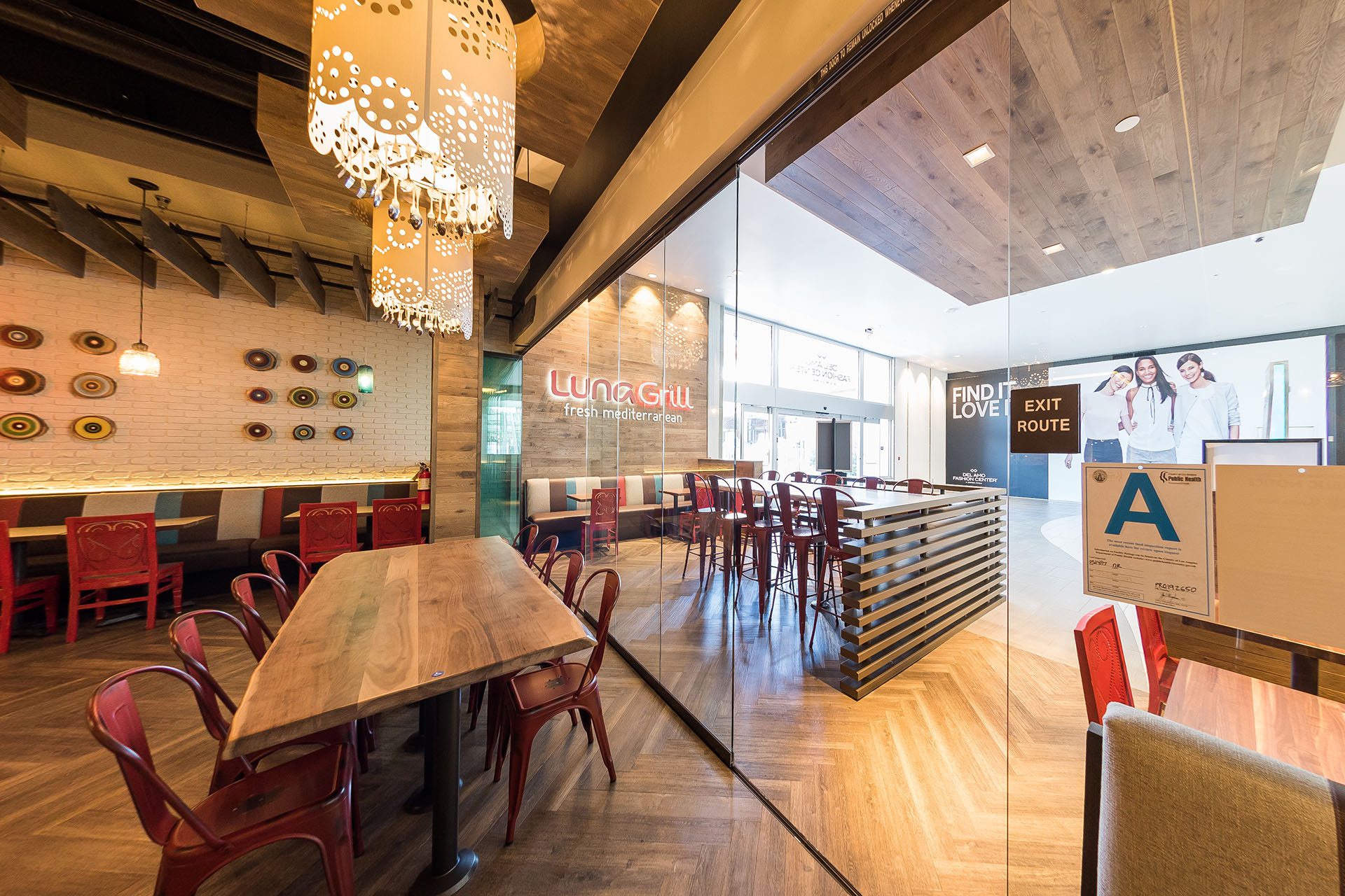 Enclosed frameless sliding glass doors inside restaurant next to table.