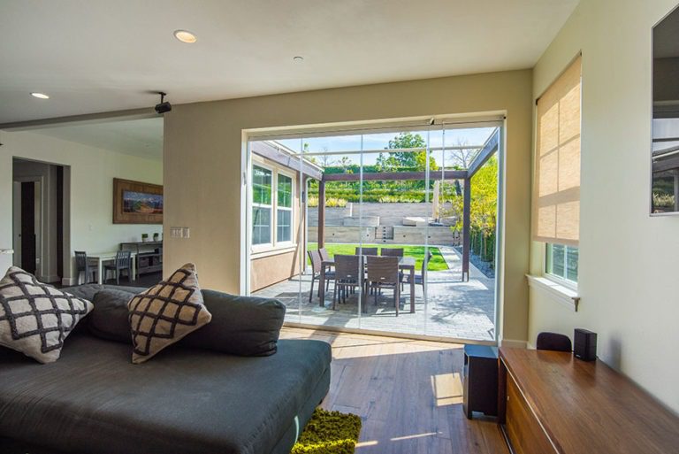 Looking from living room into backyard with enclosed frameless sliding glass doors.