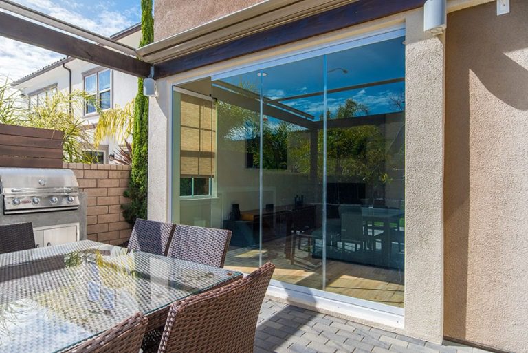 Looking from patio into living room with enclosed frameless sliding glass doors.