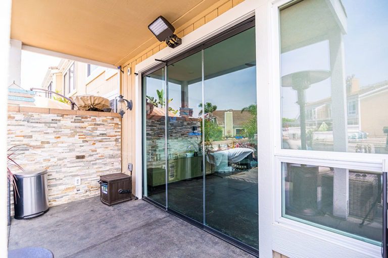 Outdoor area with closed frameless sliding glass doors.