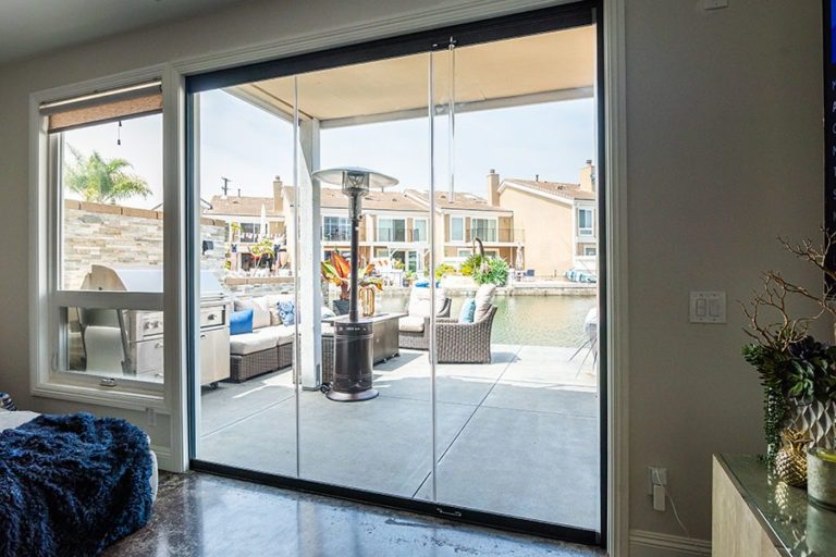 Looking at patio through enclosed frameless sliding glass doors.