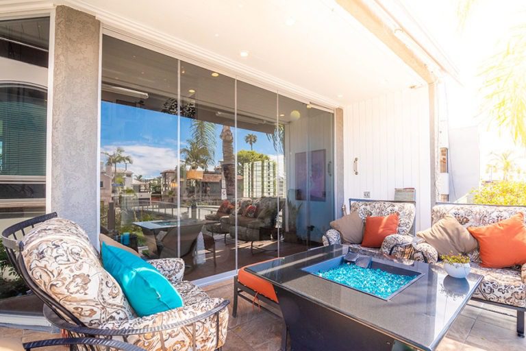 Patio area looking into living room with closed frameless sliding glass doors.