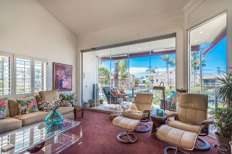 Living space with closed frameless sliding glass doors overlooking the outdoors.