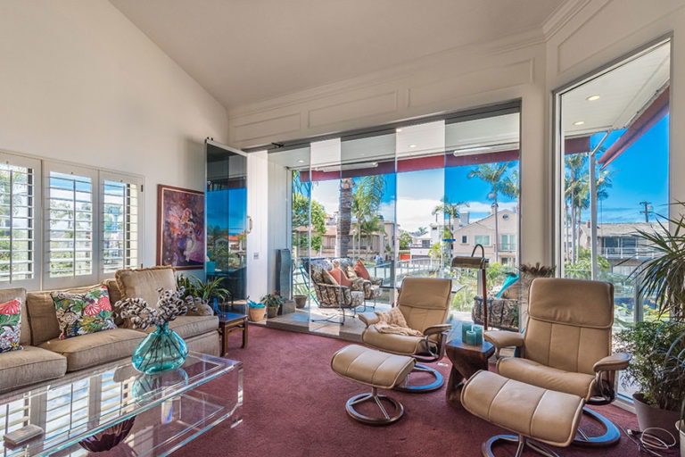 Living space with partially open sliding glass doors overlooking the outdoors.