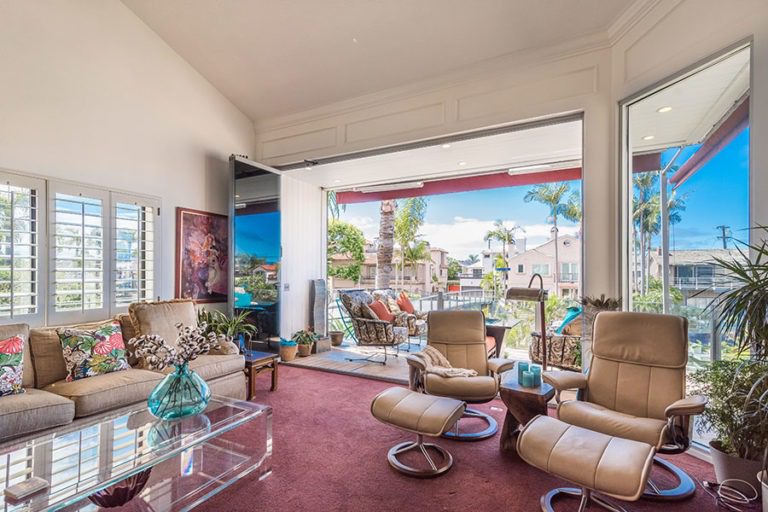 Living space with fully stacked sliding glass doors overlooking the outdoors.