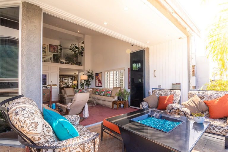 Patio area looking into the living room from having the frameless sliding glass doors fully stacked on a side.