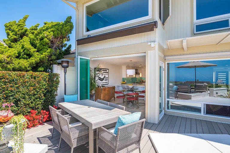 Patio table with unobstructed views looking into dining room from having the frameless glass doors stacked to one side of door frame.