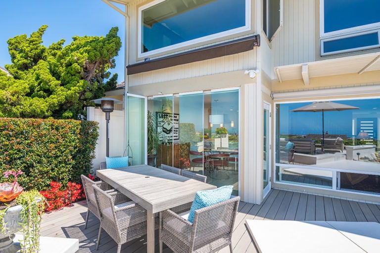 Patio table with staggered frameless glass doors with views into the dining room.