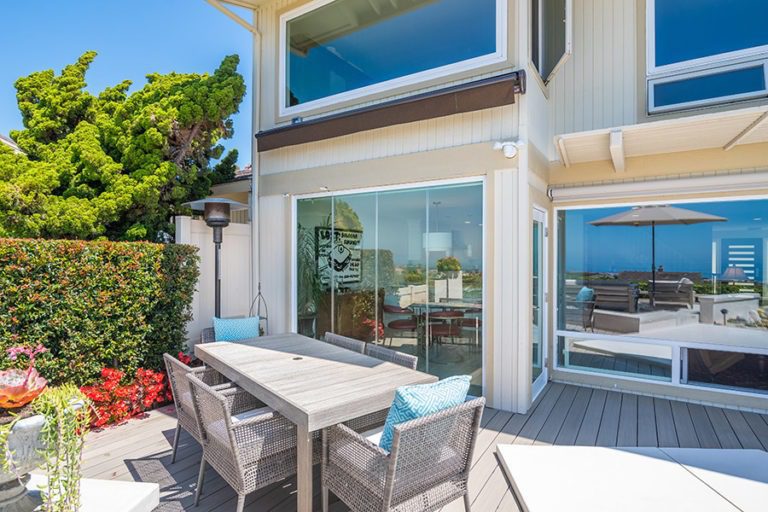 Patio table with closed frameless glass doors with views into the dining room.