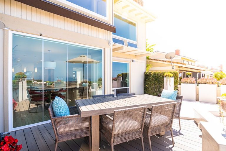 Intimate outdoor space with patio table and closed frameless glass doors.