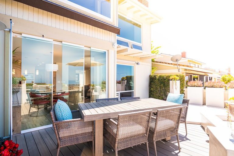 Intimate outdoor space with patio table and staggered frameless glass doors.