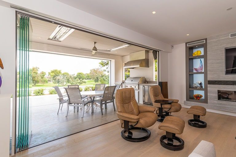 Stacked glass panels connecting a living space with the outdoors.