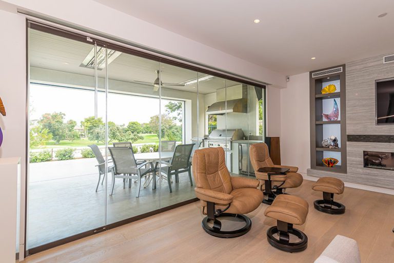 Closed frameless sliding glass doors separating a living space from the outdoors.