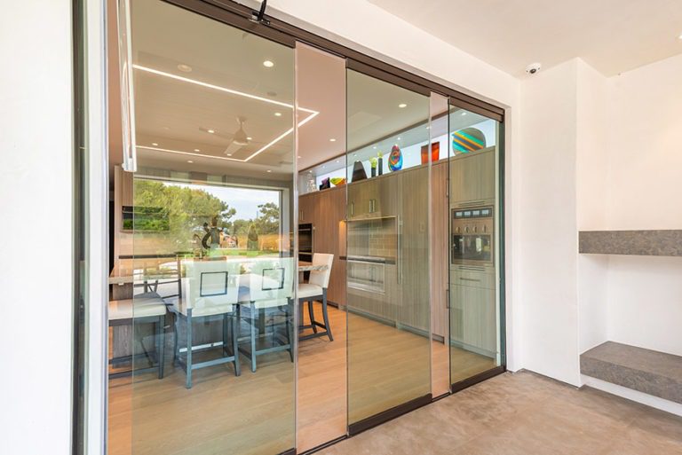 Partially open sliding glass doors showing kitchen area from patio.