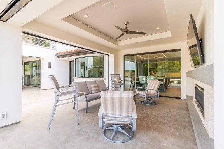 Outdoor space with patio table and tv with closed glass doors on the background.