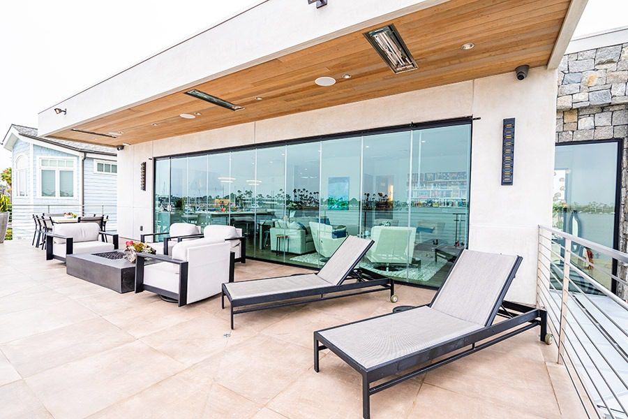 Different view from marble floored patio and fire place looking at enclosed frameless glass doors.